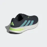 Championes de running Adidas Galaxy 7, color azul marino con tres franjas laterales en azul celeste y detalles en verde lima. Cuentan con mediasuela Cloudfoam blanca y detalles en verde lima en la parte inferior.