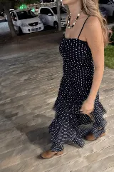 Vestido largo negro strapless de encaje con frunces en el torso, falda asimétrica en capas con volados y breteles removibles.