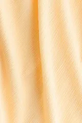 Vestido midi de algodón con textura efecto arrugado, color amarillo, tirantes finos ajustables, escote corazón con abertura tipo cerradura y lazo frontal, cintura elástica fruncida y falda evasé con vuelo ligero.