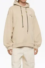 Sudadera larga de corte recto color beige, con escote redondo y capucha ajustable. Presenta mangas largas con forma, logo estampado en el pecho y cordones personalizados con nudos.
