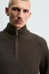 Jersey de punto perlado con cuello perkins y cierre frontal de cremallera. Presenta un corte regular fit, manga larga y acabados en rib en puños y bajo.