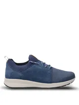 Championes casuales Hush Puppies modelo Spinal Knit, color azul marino. Presentan una combinación de tejido técnico transpirable en la puntera y laterales de cuero gamuzado. Incluyen cordones jaspeados, cuello tejido elástico y suela ergonómica de color blanco con tecnología Spinal para soporte postural.