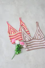 Top corto de tejido de punto crochet, con tirantes anchos y escote en V pronunciado. Presenta un diseño a rayas horizontales y en chevron en el busto, combinando color marrón claro/camel y blanco.