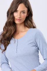 Remera de manga larga color negro, con cuello redondo y cierre frontal parcial con botones a tono. Presenta un diseño de corte recto con ruedo curvo.