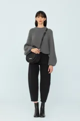 Sweater gris de tejido de punto grueso, con cuello redondo y mangas ranglán abuchonadas.