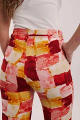 Pantalón de pierna ancha con estampado floral en tonos amarillo y gris, con cintura elastizada y cordón ajustable.