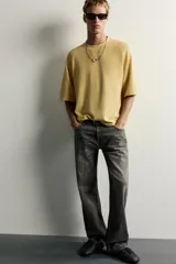 Jeans flare fit de denim de algodón en color gris con efecto lavado. Presentan diseño de cinco bolsillos, tiro medio y cierre frontal con cremallera y botón.