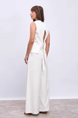 Chaleco blanco con cuello en V y cierre frontal con botones.