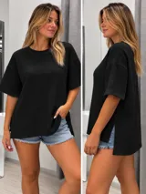 Blusa tipo remera color negro de tejido texturizado tipo bámbula, con cuello redondo, mangas cortas amplias, calce holgado y aberturas laterales en el ruedo, siendo la parte trasera más larga.