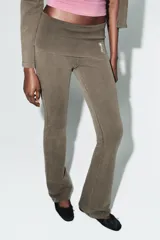 Pantalón de tiro alto con cintura doblada y diseño acampanado, confeccionado en tejido de algodón con efecto lavado. Presenta un detalle de aplicación de brillos en la cintura.