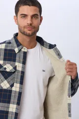 Campera tipo leñadora de viyela a cuadros, con interior forrado en corderito para mayor abrigo. Presenta cierre frontal con botones, cuello clásico y dos bolsillos frontales con solapa y botón.