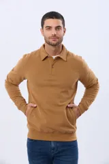 Buzo de felpa color verde oscuro, con cuello tipo polo, cierre frontal parcial con botones y bolsillos laterales. Presenta puños y ruedo acanalados.