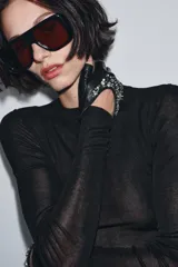 Guantes cortos tipo mitones confeccionados en piel, con diseño sin dedos y detalle de aplicación de joyas brillantes en el dorso.