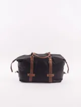 Bolso de viaje tipo duffle, confeccionado en cuero natural color azul con textura, con detalles de correas y asas en cuero color suela. Cuenta con cierre superior, bolsillo interior con cierre y compartimento para celular.