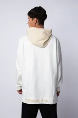 Buzo tipo canguro con capucha, confeccionado en una combinación de algodón rústico y microfibra. Presenta un diseño bicolor en tonos rosado y verde militar, con bolsillo frontal tipo canguro en contraste, cordones ajustables y estampa personalizada en el frente.