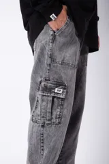 Pantalón cargo de jean con lavado ácido en tono gris, corte holgado, bolsillos laterales tipo cargo y bolsillos frontales tipo parche.