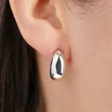 Aros dorados con forma de gota y un pequeño detalle de strass.