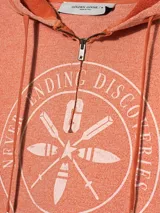 Buzo corto con capucha color naranja, con cierre frontal y estampado circular en el pecho.