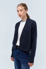 Cardigan de tejido de punto liviano, con escote en V y cierre frontal abierto. Presenta mangas largas y un corte recto, confeccionado en lana italiana.