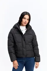 Campera puffer negra con capucha, diseño corto y acolchado, cierre frontal con botones a presión y puños ajustados.