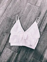 Top color rosa con breteles finos, escote en V y doble volado en el ruedo.