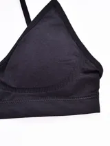 Sostén tipo top básico seamless de color negro, con copas triangulares y tirantes finos regulables.