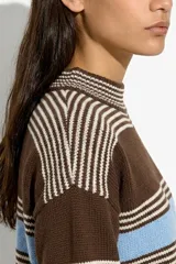 Sweater tejido de punto corto, con cuello redondo y diseño a rayas horizontales en tonos marrón, blanco y celeste.
