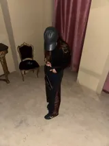 Jean negro de corte recto con inserciones laterales de encaje marrón con diseño floral en las perneras y terminación desmechada en el bajo.