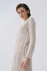 Sacón largo de tejido de punto con rayas verticales en tonos azul, rosa, amarillo y negro. Tiene mangas largas, cuello en V y cierre frontal con lazos.