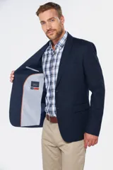 Saco sport azul marino de lino, con solapa de muesca, cierre de dos botones, bolsillo en el pecho y bolsillos delanteros con solapa. Corte entallado.