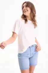 Remera blanca de algodón de manga corta con corte holgado y pequeño parche con texto en el pecho.
