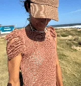 Musculosa tejida color violeta con diseño calado y flecos en los hombros.