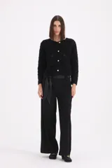 Pantalon de vestir negro de corte recto y tiro alto, con cintura ancha y cinto de lazo integrado en la misma tela.