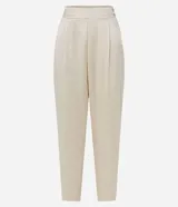 Pantalón de satén color crema, corte carrot, con cintura alta, pliegues, bolsillos laterales y cierre con cremallera.