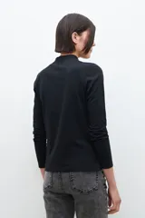 Remera de manga larga color blanco, con cuello alto con volados.