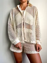 Camisa de playa color crema, de tejido crochet con botones frontales y cuello clásico.