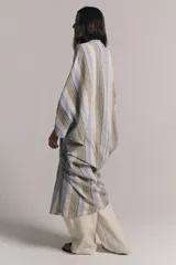 Túnica midi ZARA Woman Collection confeccionada en hilatura con mezcla de lino, con diseño a rayas en tonos beige, gris y azul. Presenta escote en V, manga por debajo del codo, detalle de frunces en el delantero y bajo asimétrico.