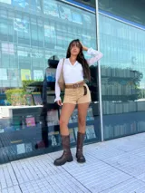 Remera blanca de encaje con diseño cruzado tipo wrap, mangas largas con terminación acampanada y detalle de bordado floral a tono. Presenta un ajuste al cuerpo con lazo lateral y borde con terminación delicada en el escote.