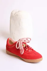 Zapatillas bajas marrones de gamuza con cordones y detalle de aplique de fresa en los cordones.