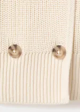 Chaqueta de punto de algodón color marfil, con diseño recto, cuello camisero, manga larga y cierre de doble botonadura con botones carey.