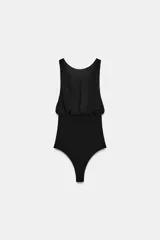 Body negro de cuello barco y tirantes con aplicación de lazos a tono. Cierre en bajo con botones a presión y en espalda con cremallera.