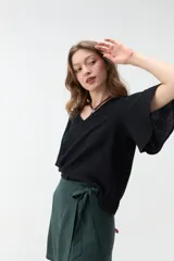 Blusa negra de manga corta con escote en V y diseño amplio y ligero.