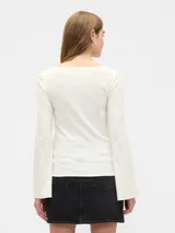 Remera de manga larga con cuello bote, confeccionada en tejido de punto acanalado de textura suave y ajuste entallado.