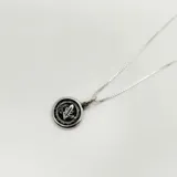 Collar de plata 925 con cadena de eslabones finos y dije circular con diseño grabado en relieve que representa un símbolo relacionado con la economía.
