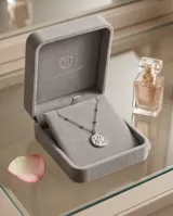 Collar de acero con cadena de eslabones finos intercalados con pequeñas esferas metálicas. Presenta un dije circular con diseño de estrella central en nácar.