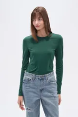 Remera verde esmeralda de manga larga, corte ajustado y cuello redondo.