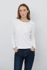 Remera de manga larga en color azul marino, confeccionada en tejido suave. Presenta un delicado detalle de bordado festoneado en color blanco tanto en el cuello redondo como en los puños, aportando un toque distintivo a esta prenda básica.