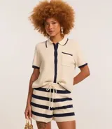 Blusa color crema con cuello inglés y detalles en azul marino, de punto más sostenible, en modelo comfort. Posee cuello inglés, manga corta, abotonado delantero, bolsillo y detalles contrastantes.