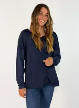 Blusa de manga larga en color azul marino, con cuello en V y diseño holgado. Presenta una costura vertical central y acabado satinado.