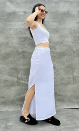 Pollera larga blanca de tela satinada con tajo lateral.